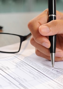 Primo piano di una mano che firma un documento 