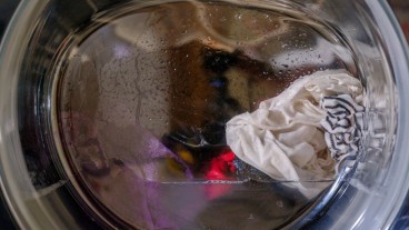 Lavatrice con bucato e acqua nel cestello