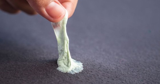 uomo elimina gomma da masticare dal divano