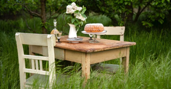 Un tavolo e sedie vinrage in legno grezzo perfette per un giardino shabby