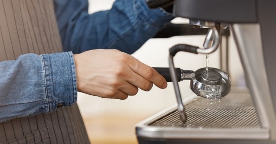 Un barista esegue la pulizia della macchina del caffè