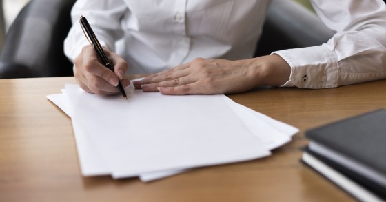 Donna concentrata a firmare un documento