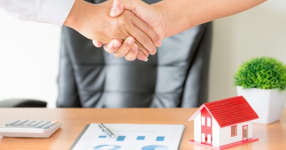 Agente-cliente, stretta di mano dopo contratto firmato per l’acquisto di un nuovo appartamento
