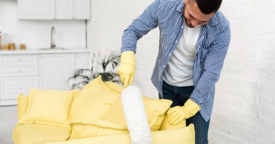 Divano giallo spolverato con un piumino