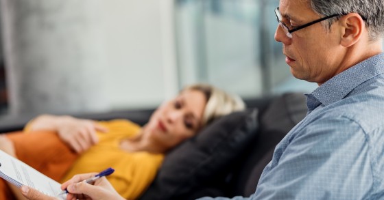 Psichiatra prende appunti mentre ha un colloquio con una paziente nel suo studio