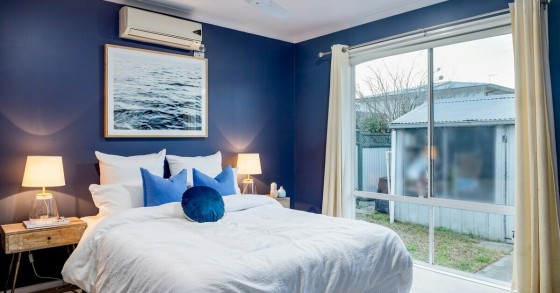 Condizionatore sopra il letto su una parete blu