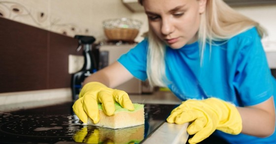 Una donna passa una spugna sul piano a induzione