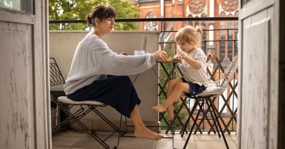 Mamma e bambino giocano su un balcone arredato