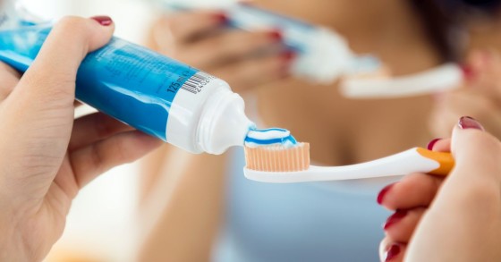 donna mette dentifricio su spazzolino 