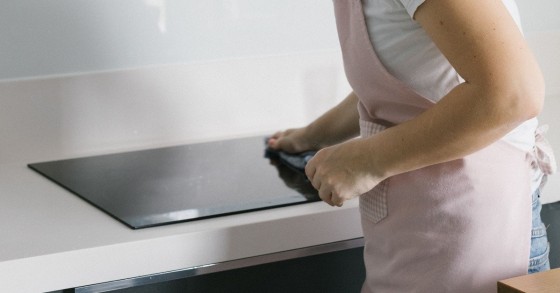 Donna pulisce un piano a induzione