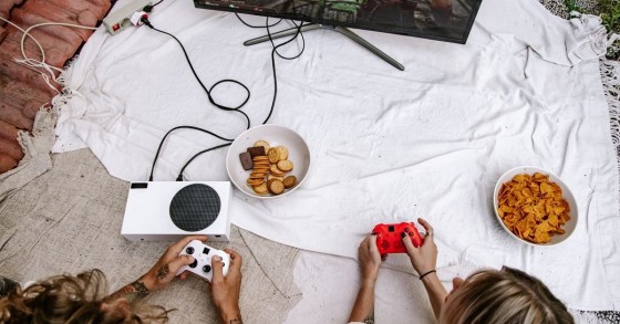 Due persone usano una console collegata alla TV per giocare
