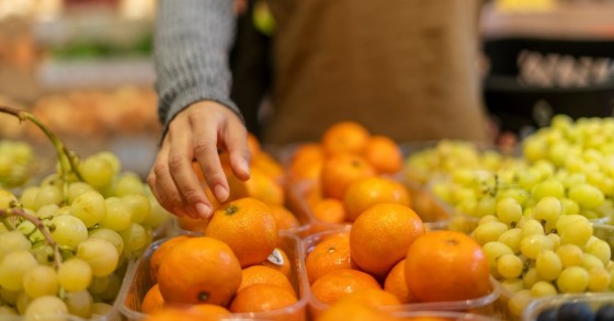 Frutta con bollini esposta in un supermercato