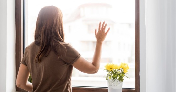 Donna guarda fuori dalla finestra
