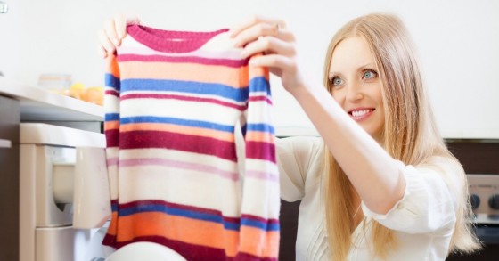 Donna estrae un maglione dalla lavatrice