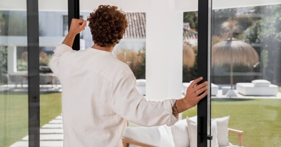 Uomo davanti a una porta-finestra aperta