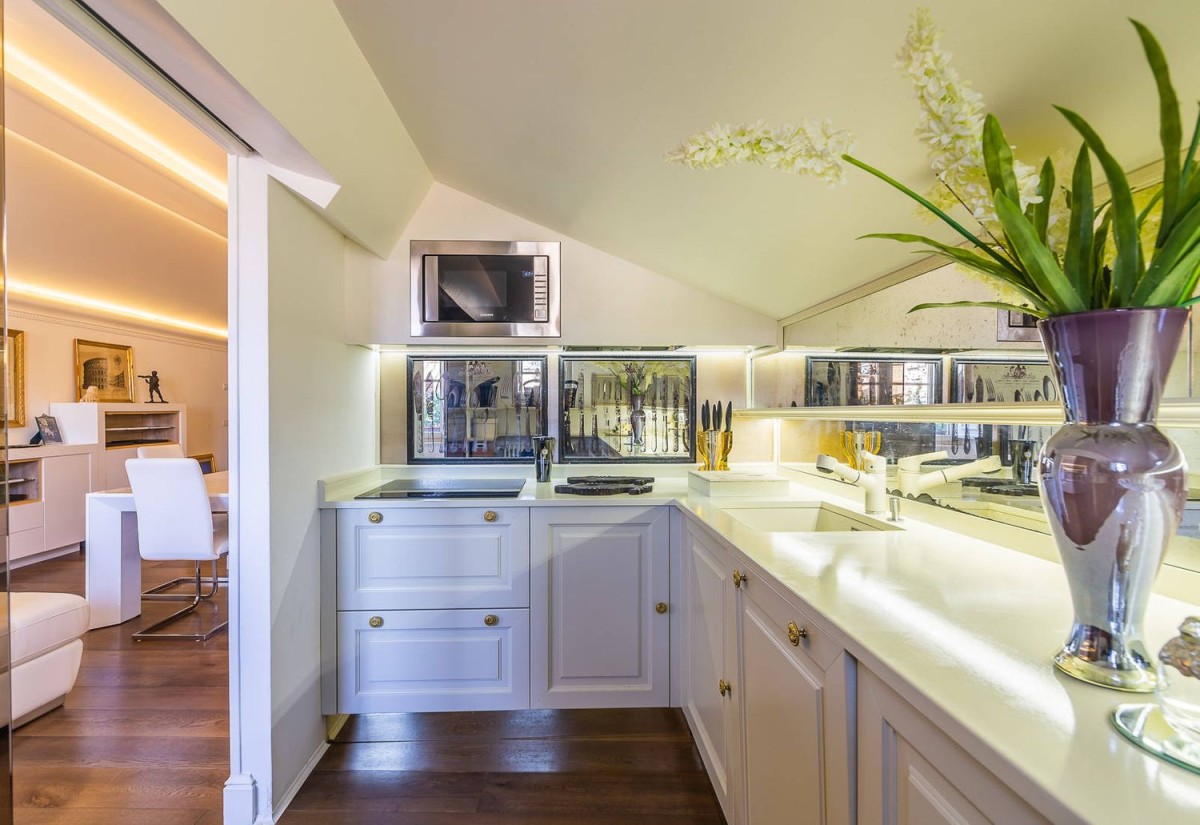 A cozinha é moderna e abre-se para uma sala de estar/jantar moderna