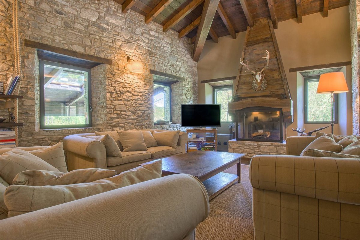 One of the living rooms has a beautiful fireplace and ceiling beams