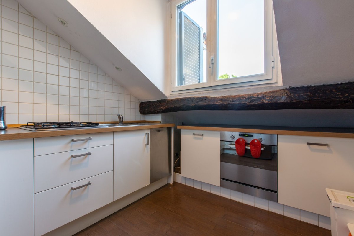 The kitchen is fitted with modern appliances along with the rustic wooden beams