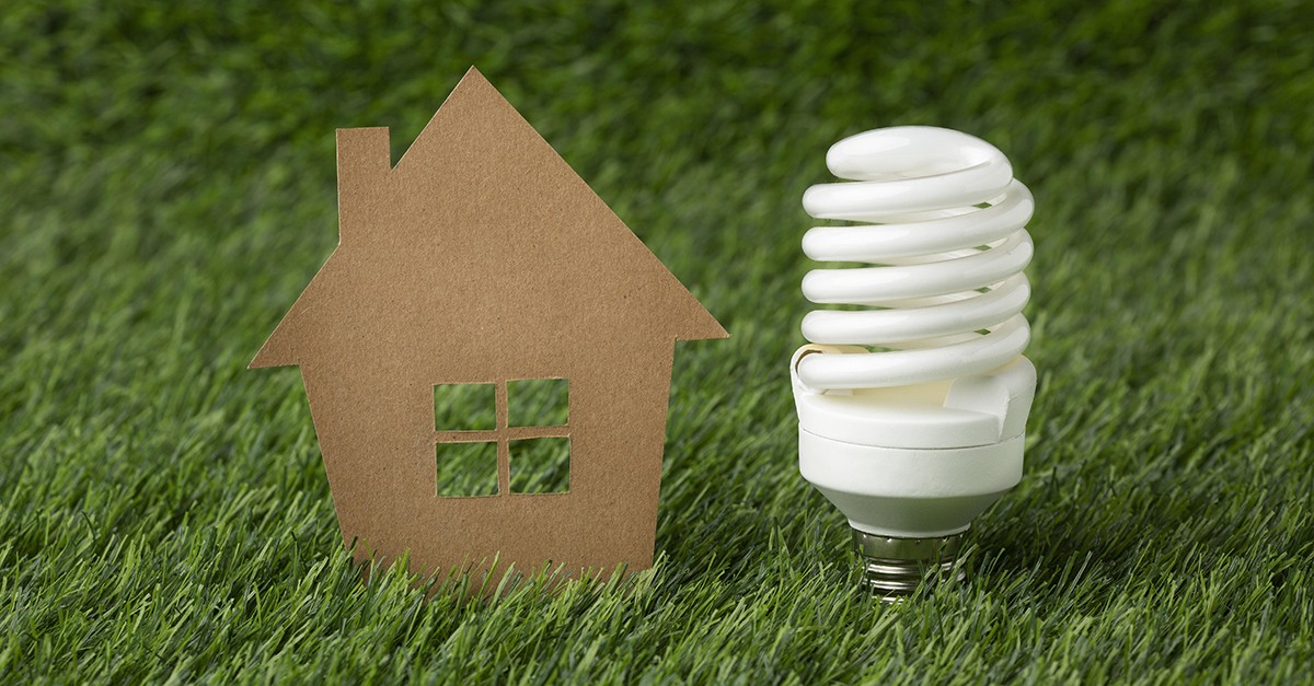 lampadina con casa in miniatura