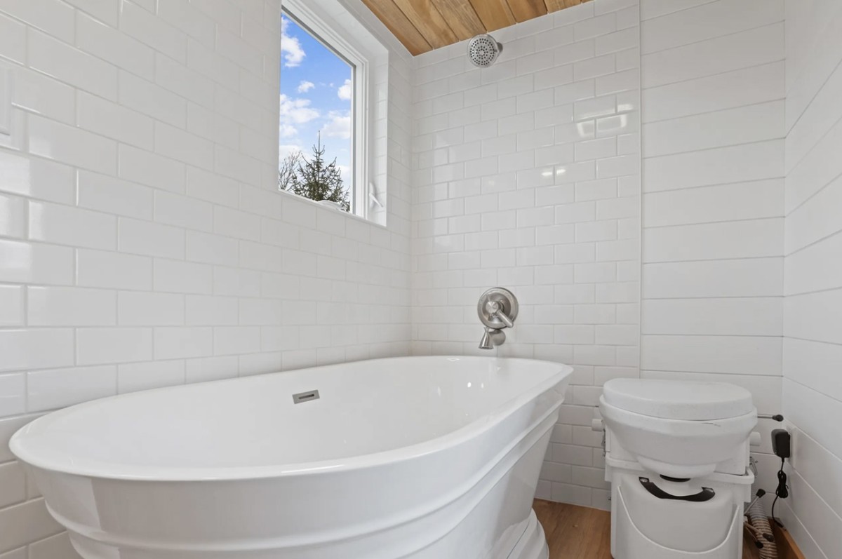 El baño cuenta con un inodoro de compostaje, un lavabo y una amplia bañera. Además, también dispone de una lavadora/secadora.