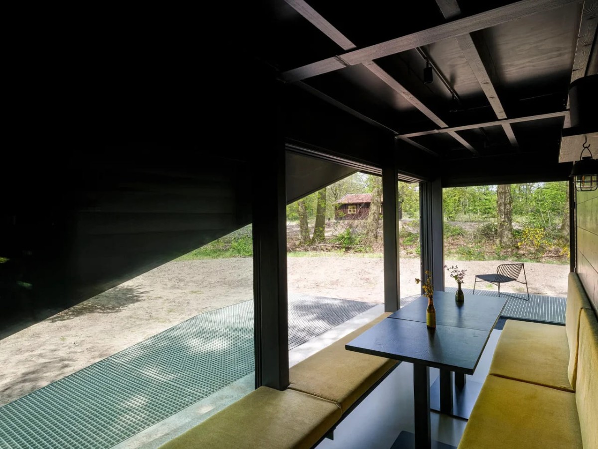 El primer nivel alberga un salón con asientos, una mesa de comedor, una cocina integrada y un baño.