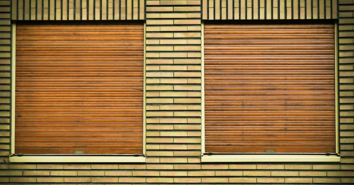 due tapparelle chiuse su un muro di mattoni