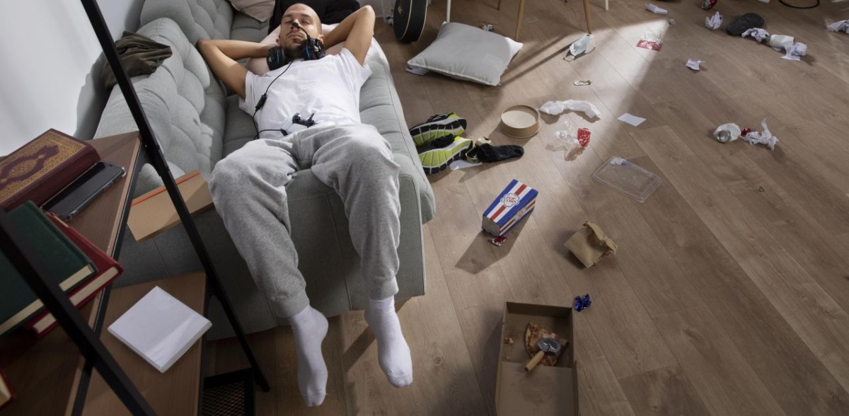 uomo appisolato in un appartamento disordinato uomo appisolato in un appartamento disordinato