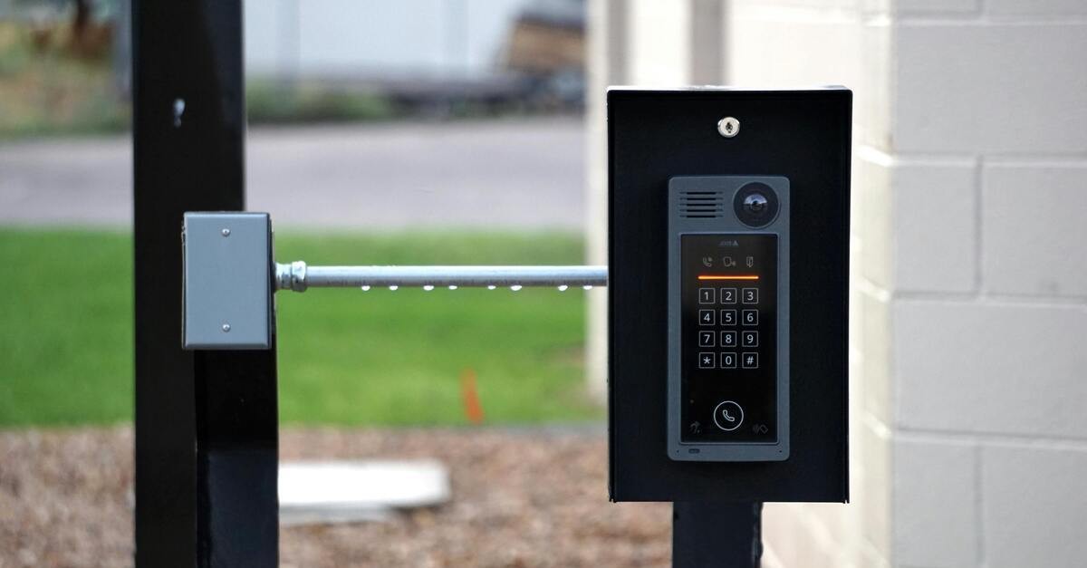 Un citofono nero con telecamera e sbarra di entrata