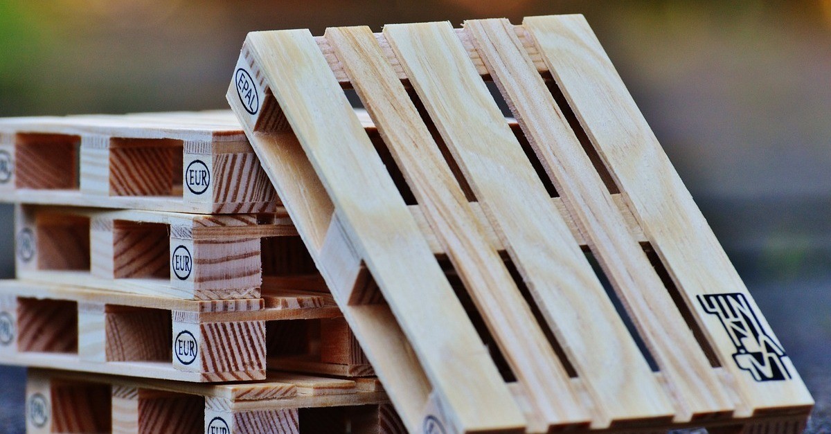 Una serie di bancali chiari con impresso il simbolo europeo 