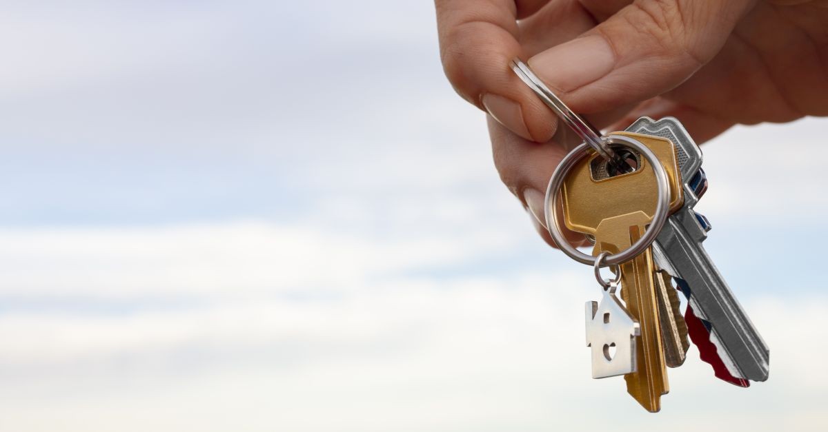 Mano maschile che consegna mazzo di chiavi