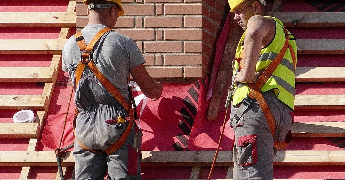Due operai lavorano sul tetto di un'abitazione per inserire il cappotto termico