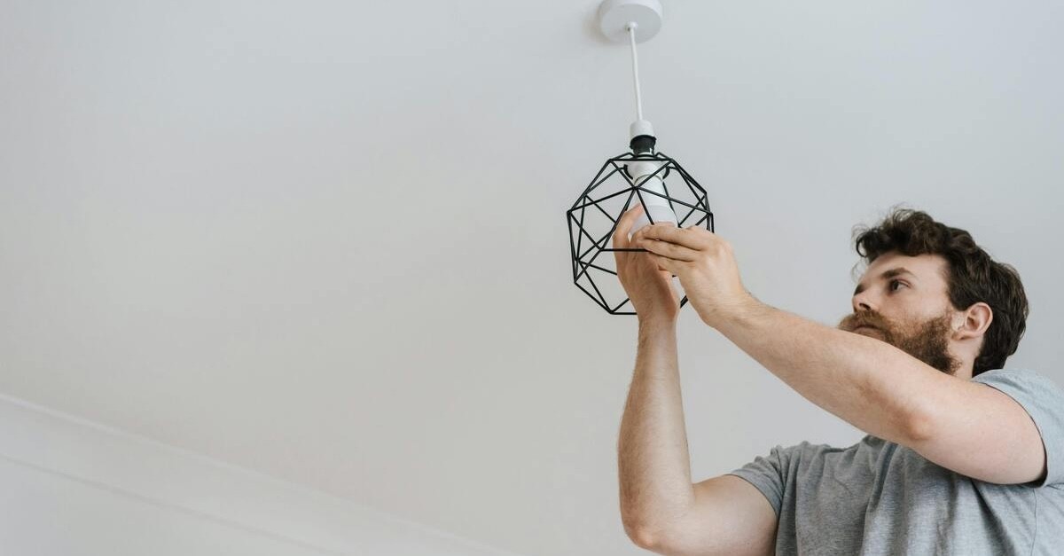 uomo monta lampadina per luce elettrica