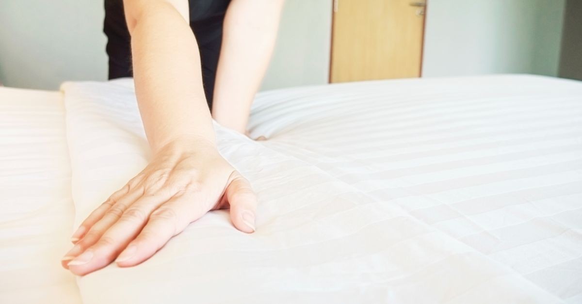 donna che sistema il letto