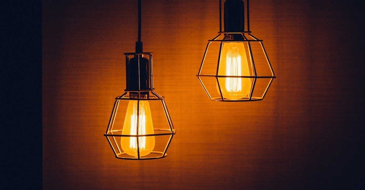 Due lampade dalla luce calda su uno sfondo amaranto Due lampade dalla luce calda su uno sfondo amaranto