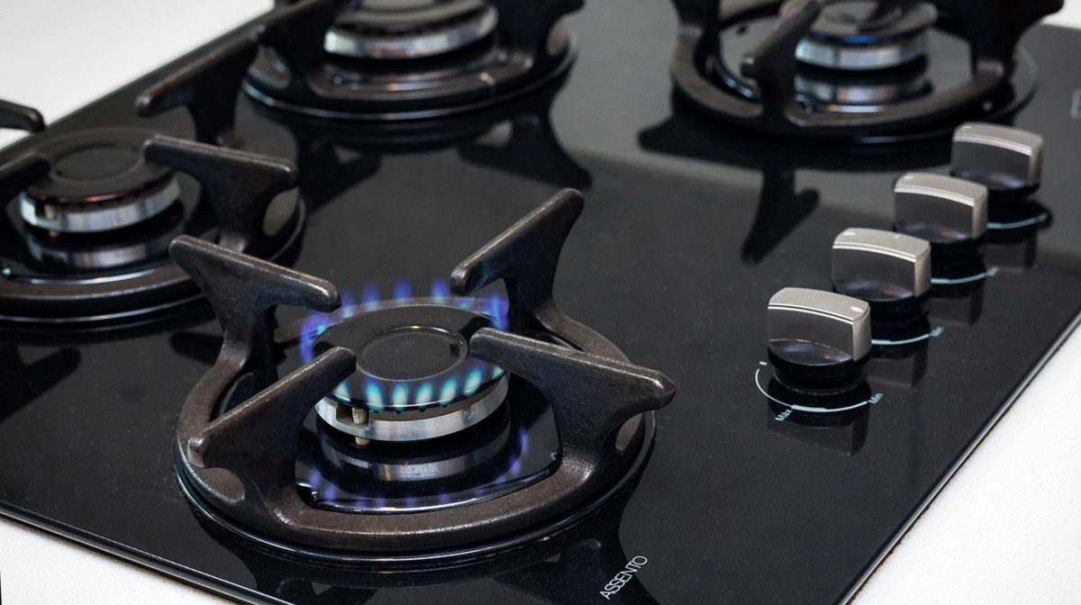 Una cucina a gas nera con un fuoco acceso Una cucina a gas nera con un fuoco acceso