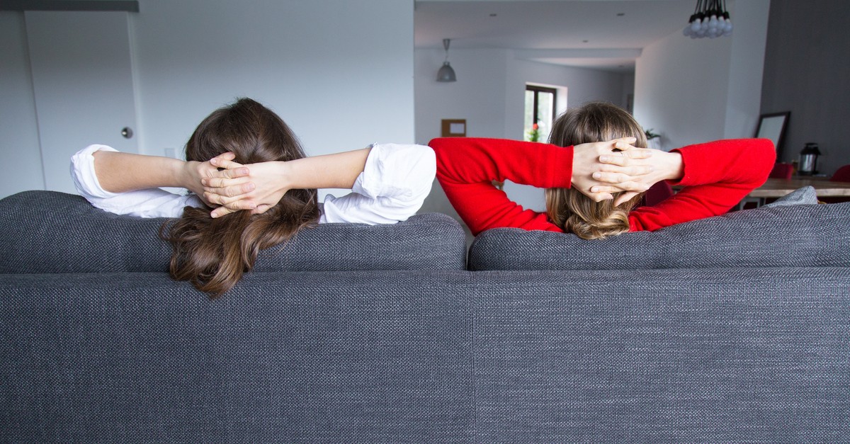 Due ragazze sedute su un divano di spalle