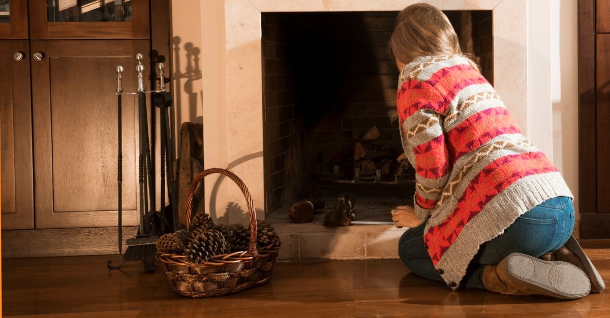 donna che accende il camino con le pigne secche