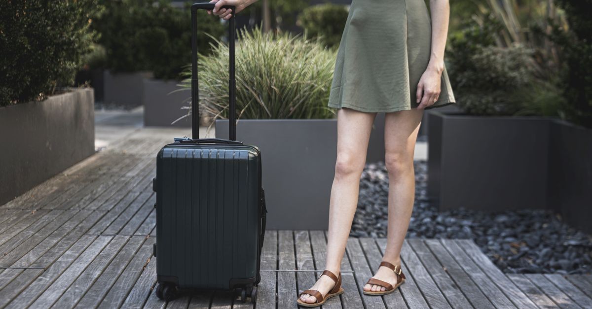 ragazza con valigia che aspetta di entrare 