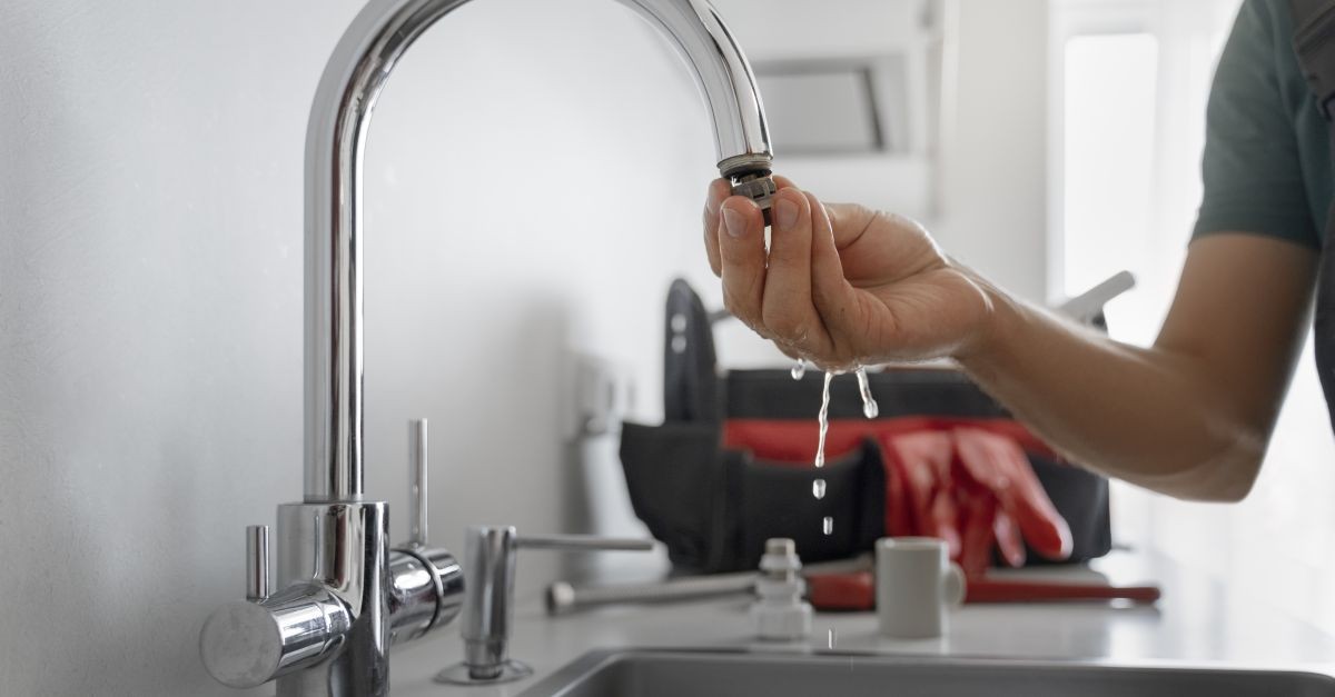 uomo che lavora a un rubinetto