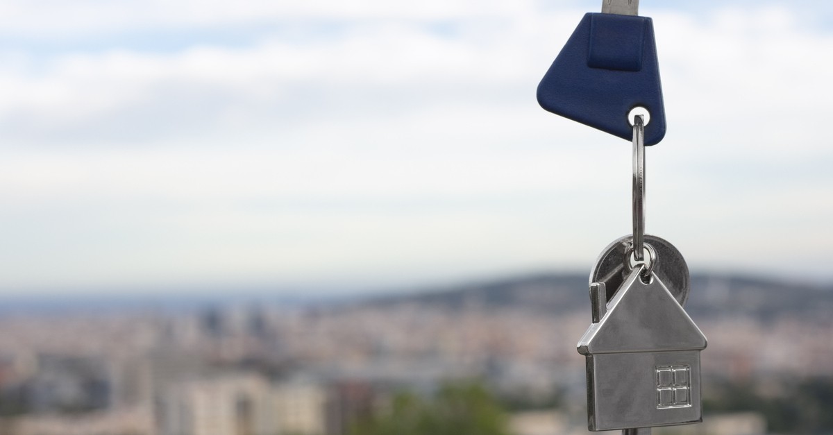 La chiave di un portone in un portachiavi in metallo a forma di casa