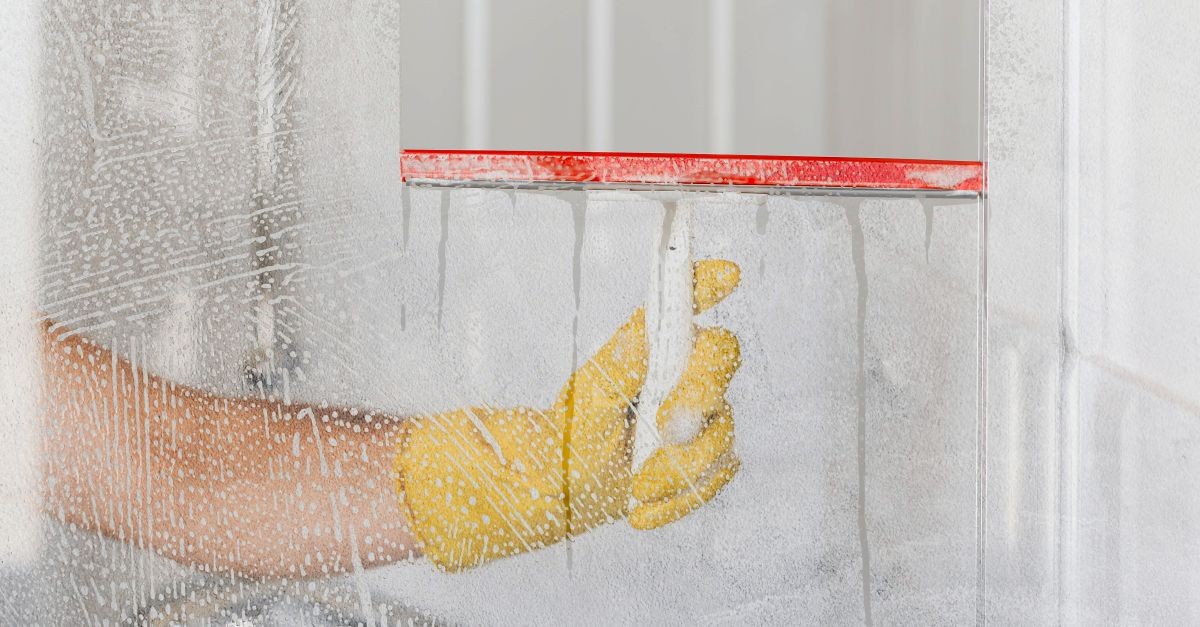 uomo passa tergivetro su box doccia