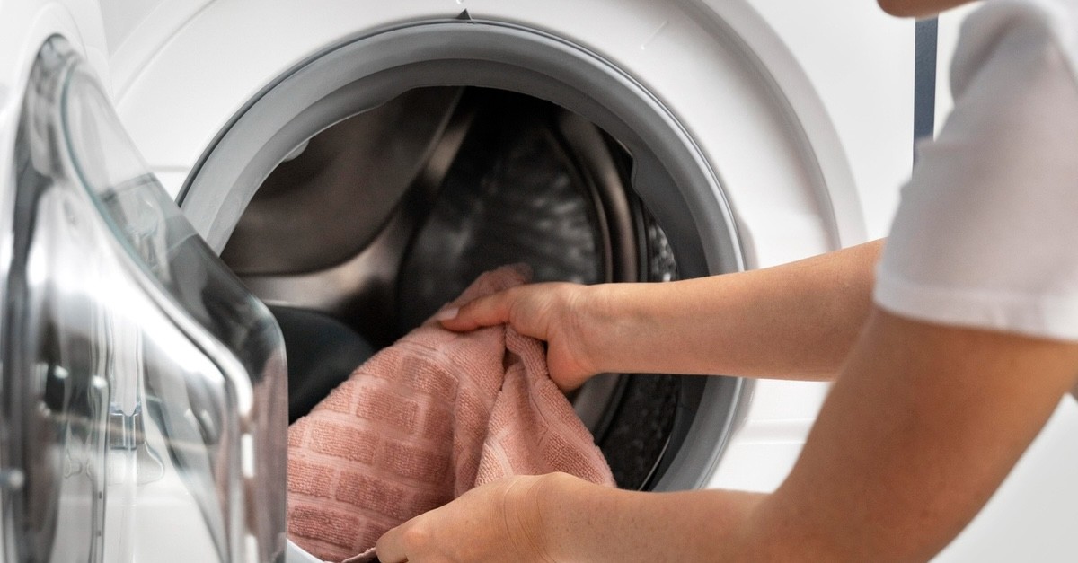 donna che prende vestiti dalla lavatrice donna che prende vestiti dalla lavatrice