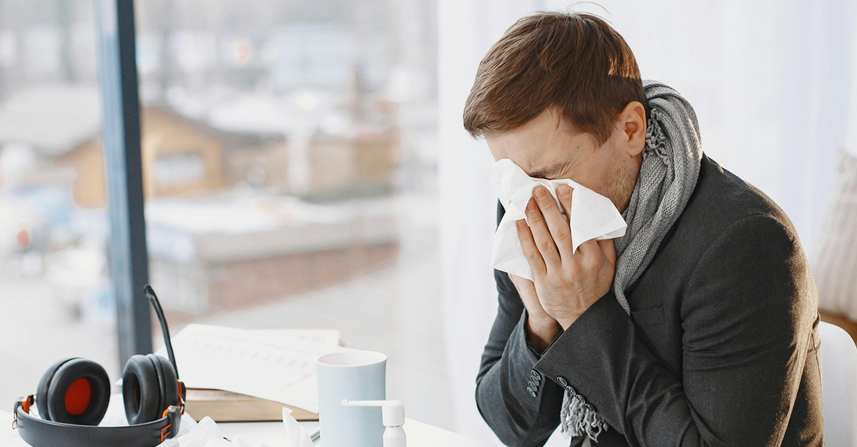 un uomo si soffia il naso