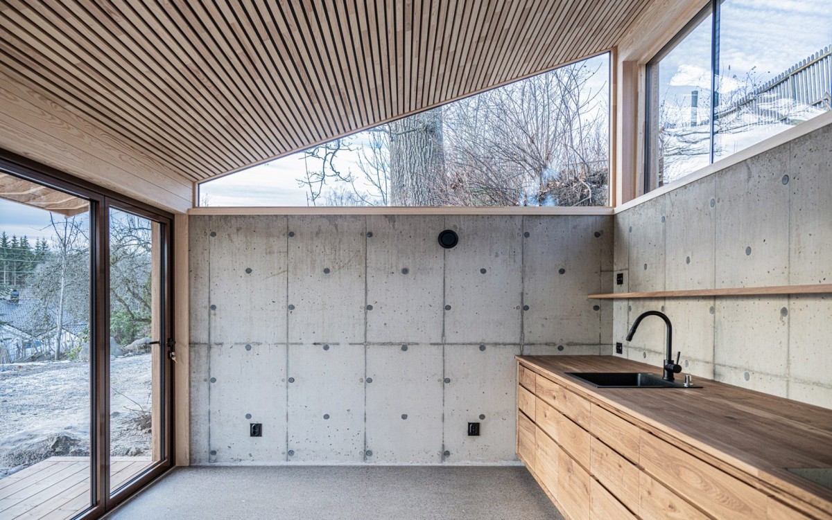 La cocina y el comedor se abren hacia el jardín mediante puertas correderas de vidrio que bañan el espacio de luz.