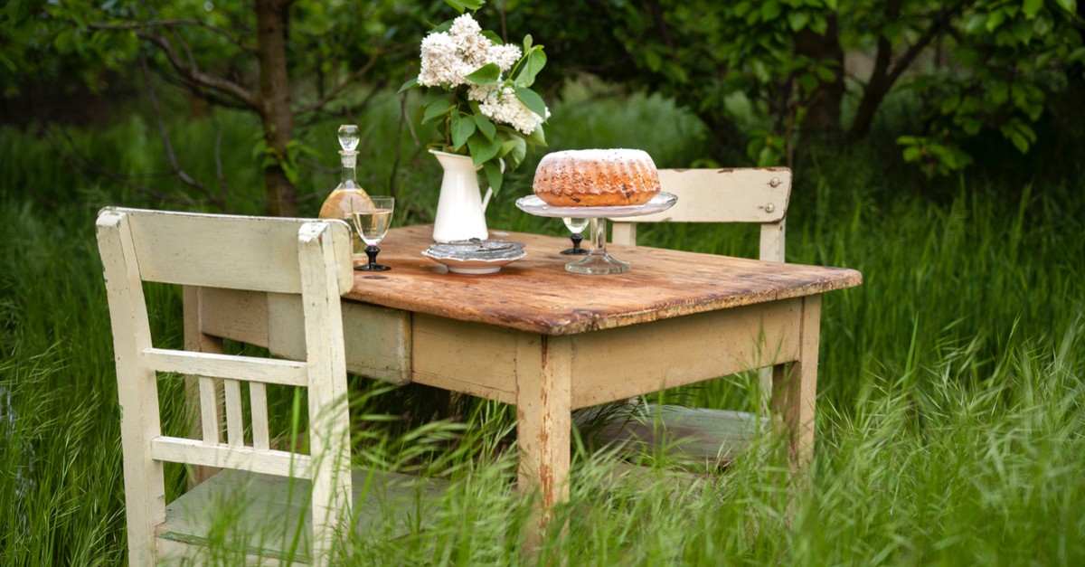 Un tavolo e sedie vinrage in legno grezzo perfette per un giardino shabby