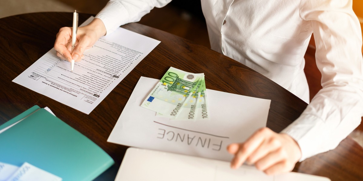 donna che lavora con le finanze sul tavolo soldi documenti