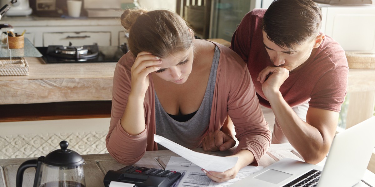Coppia preoccupata che esamina le finanze famiglia e calcola spese