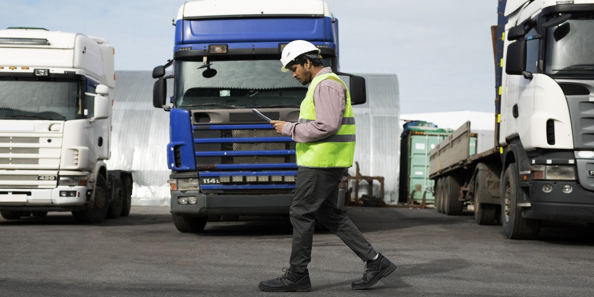 uomo cammina con la flotta di camion