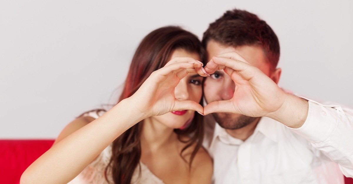 Marito e moglie che fanno segno del cuore