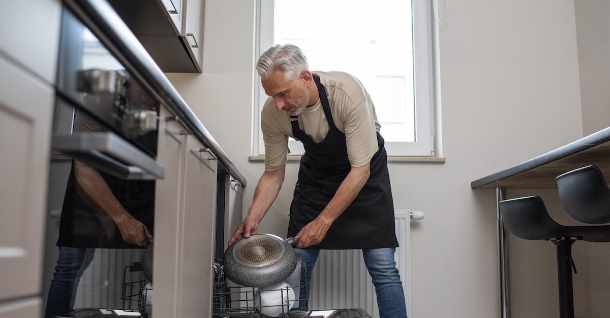 Gestione della lavastoviglie in casa uomo alle prese con la lavastoviglie